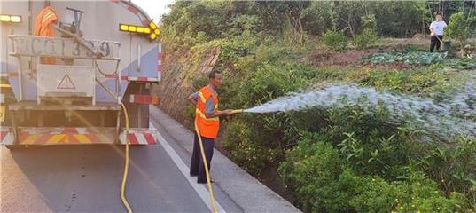 1大足公路養(yǎng)護中心工人為轄區(qū)公路沿線花草澆水解渴。特約通訊員 蔣文友 攝